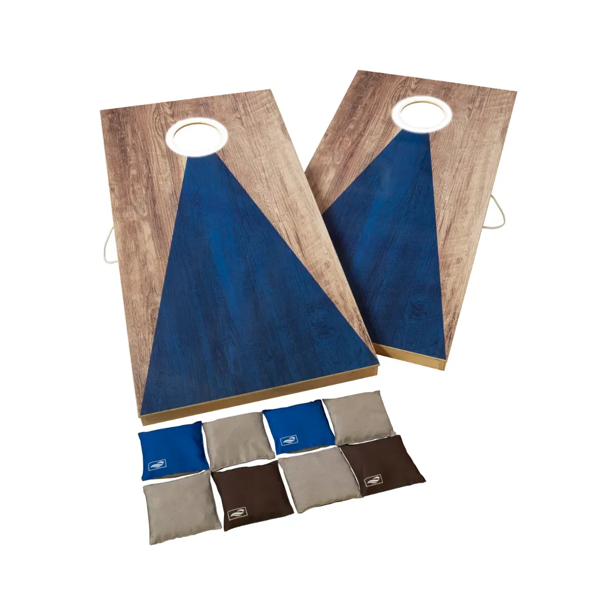 Two rectangular cornhole boards standing on folding legs, each finished in weathered wood with a deep blue triangle painted up the middle and a white LED ring lit around the hole, with eight canvas bean bags laid out in rows below them — four grey, two blue and two brown