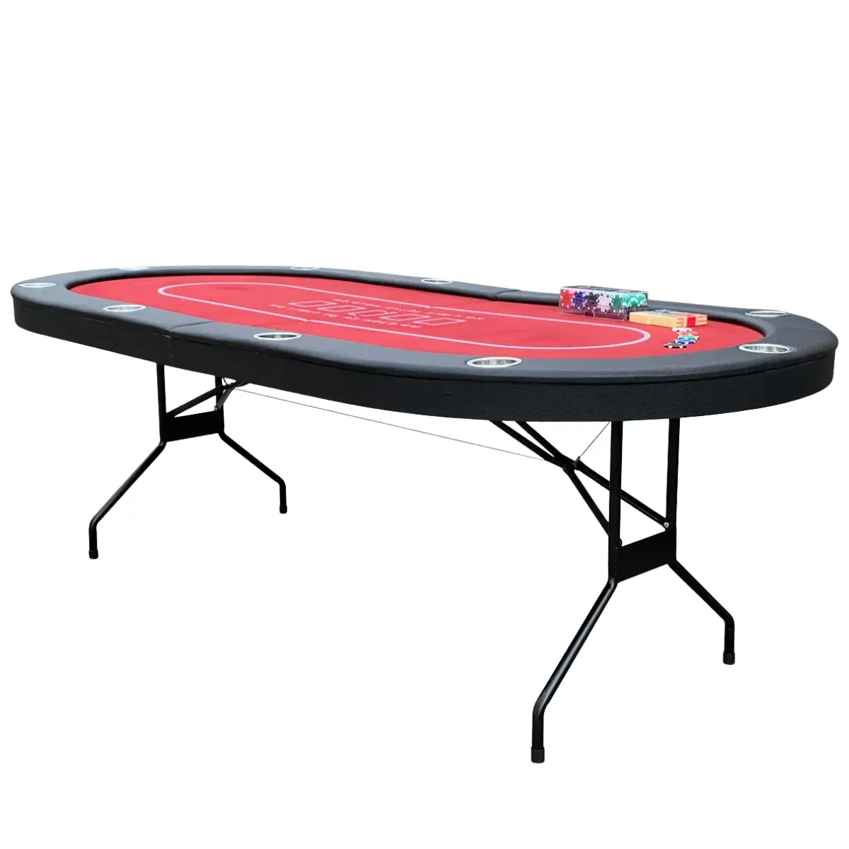 A long oval poker table with red felt marked out for Texas Hold’em, a padded black rail set with steel cup holders around the edge and black folding steel legs underneath, a rack of chips and two card decks left sitting on the felt