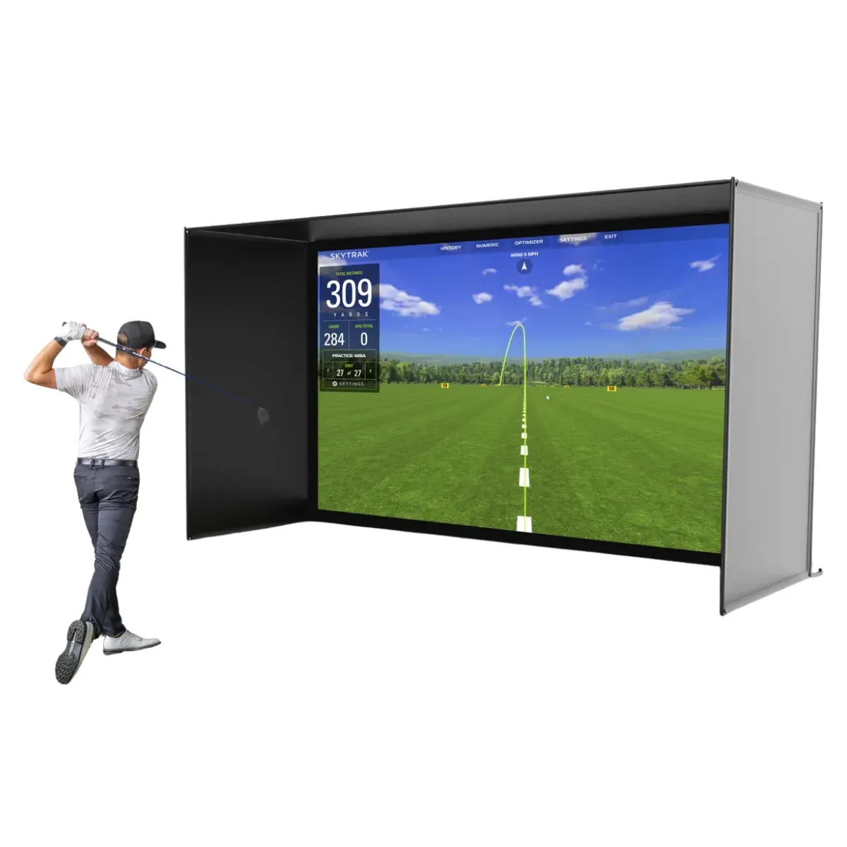A golf simulator enclosure with padded side and top panels around a wide impact screen, a driving-range view and shot distances projected onto it, and a golfer mid follow-through at the open side