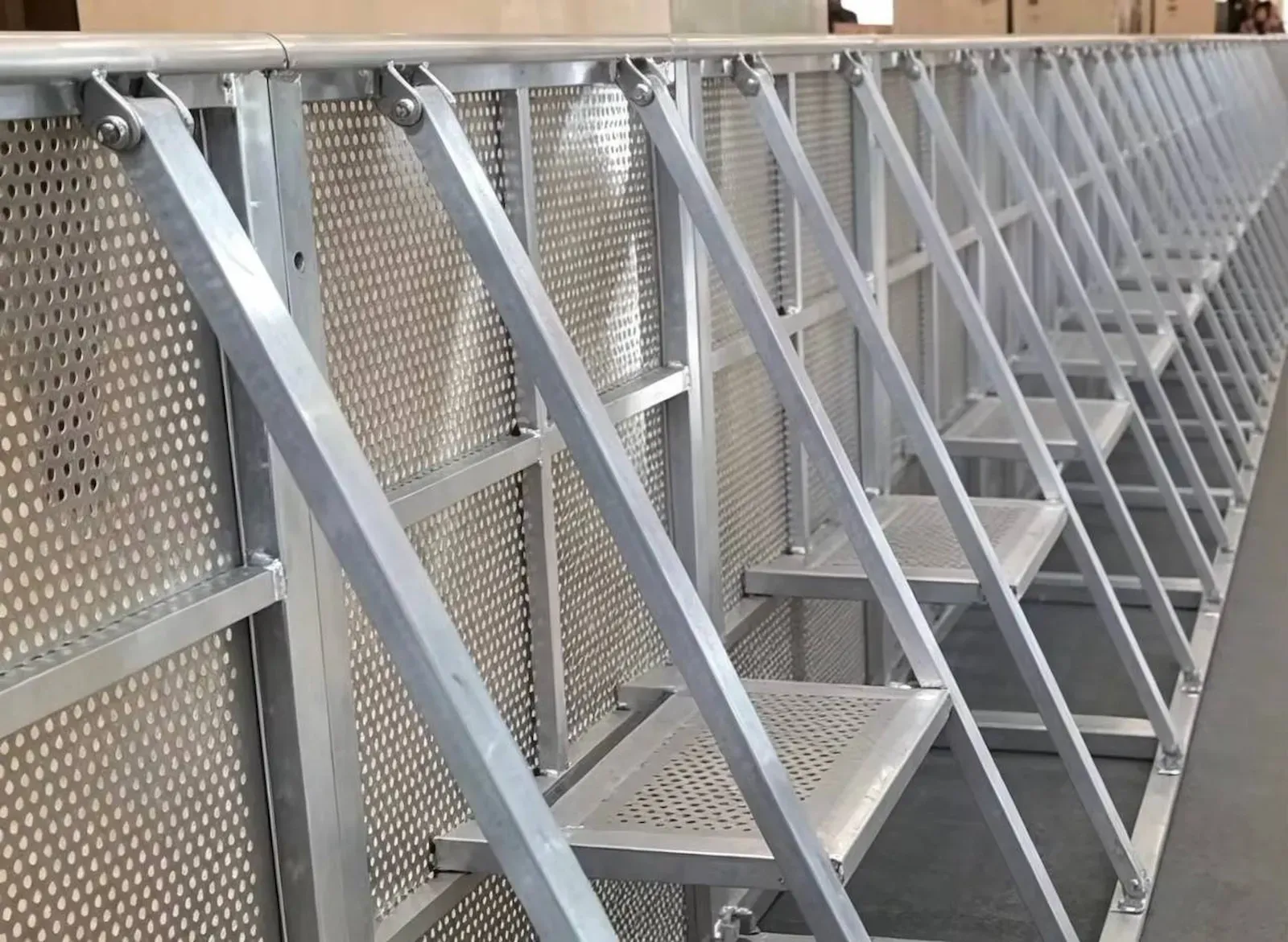 A built run of stage barrier photographed along the back, every section braced to the next with the steps facing down the line