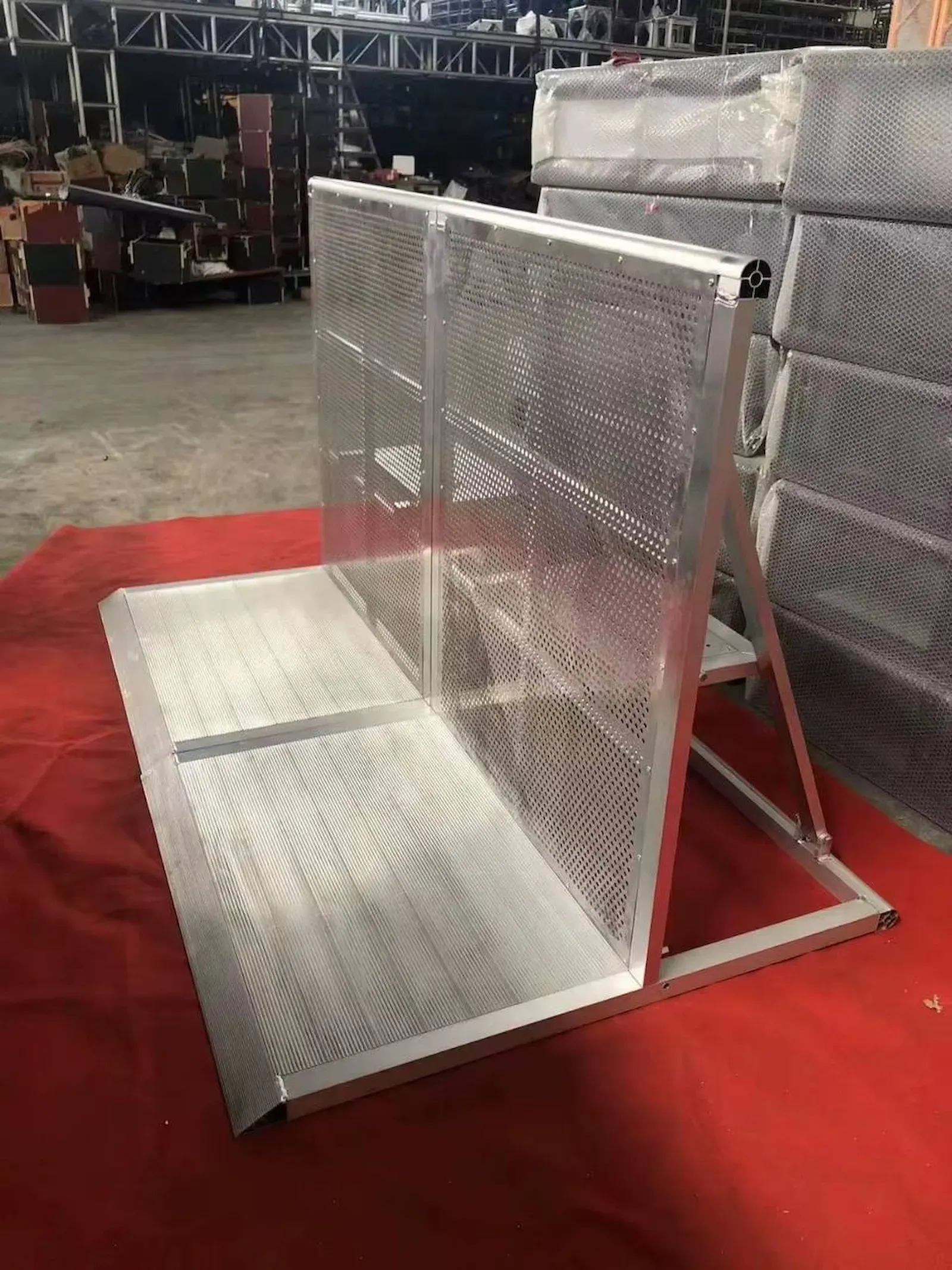 A single section standing open on a red floor covering during a load-in, more of the run stacked behind it